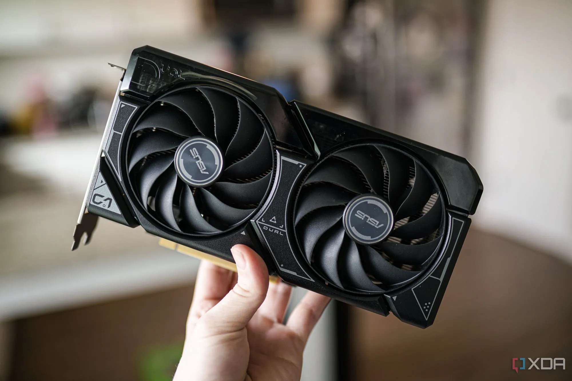 Một bàn tay đang cầm card đồ họa Nvidia RTX 4060, một mẫu GPU thuộc thế hệ hiện tại