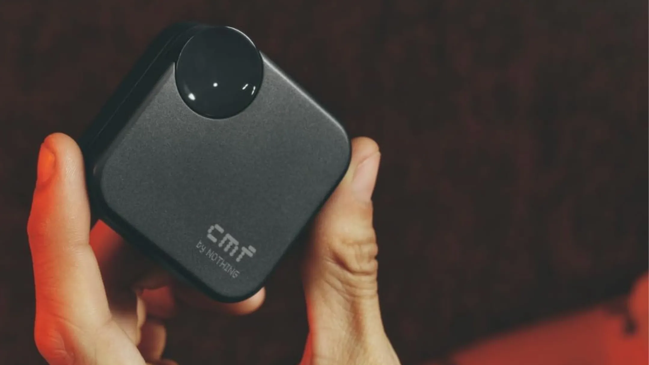 Người đang cầm hộp sạc tai nghe không dây CMF Buds 2a