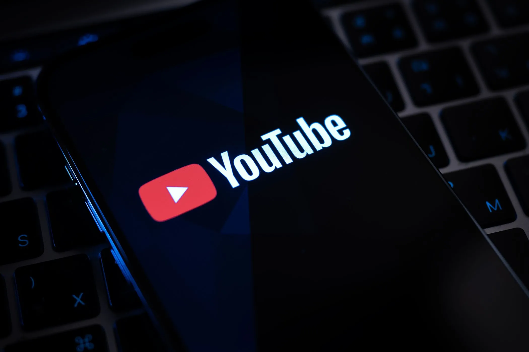 Logo YouTube hiển thị trên màn hình điện thoại thông minh, tượng trưng cho tính năng mới và an toàn nội dung
