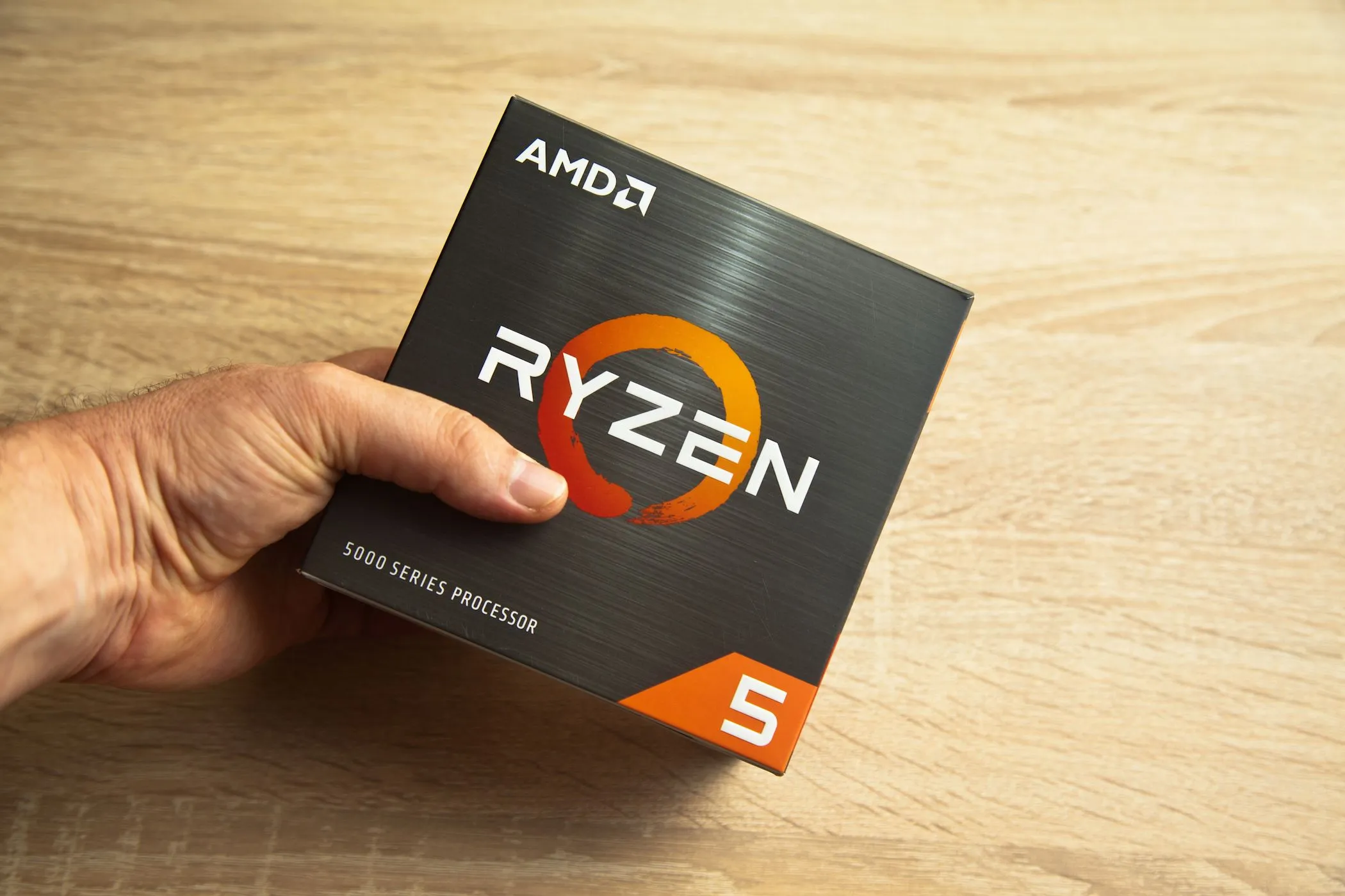 Người đàn ông đang cầm hộp vi xử lý AMD Ryzen 5000 series.