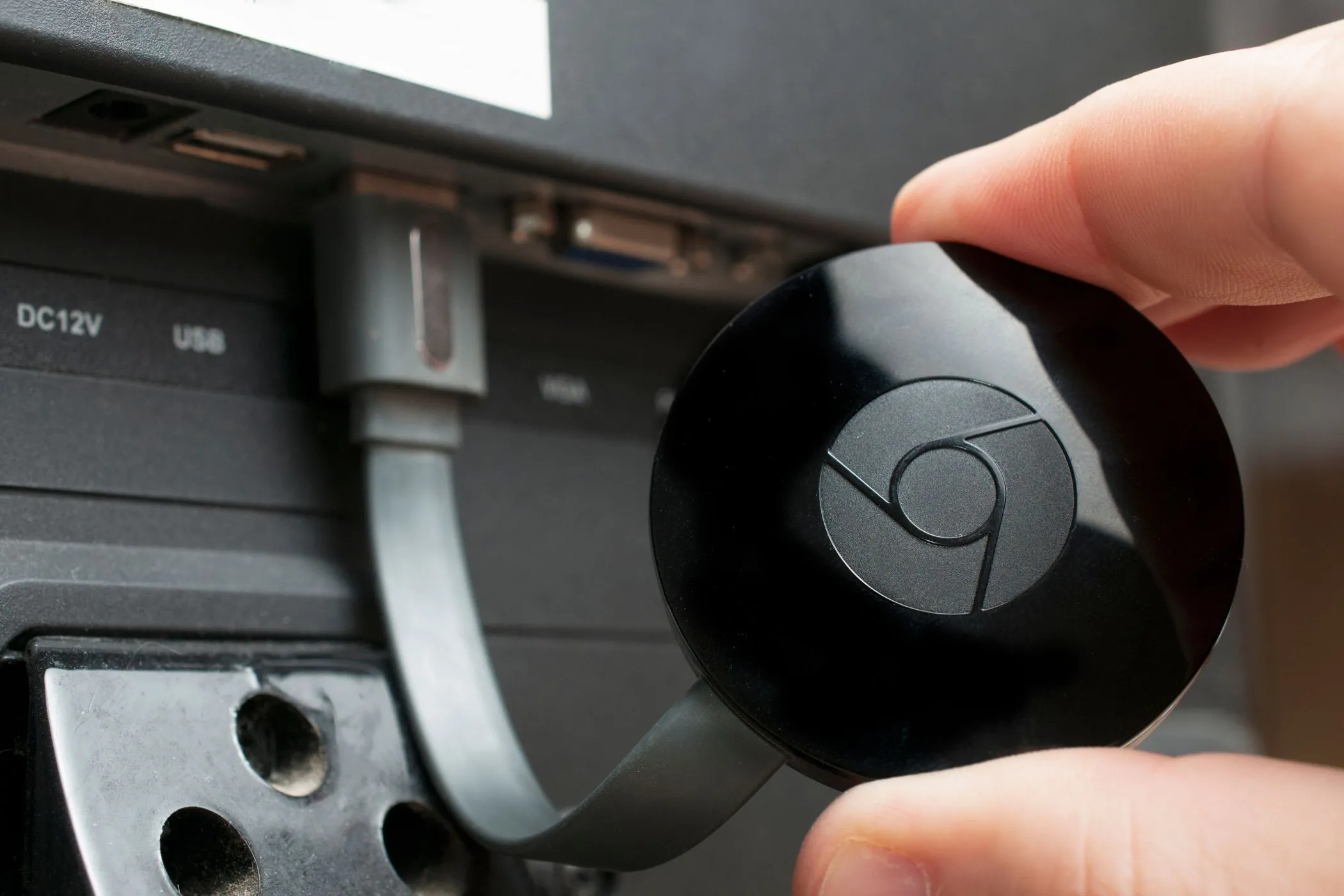 Thiết bị Google Chromecast được cắm vào cổng HDMI của TV, minh họa cách truyền nội dung từ iPhone
