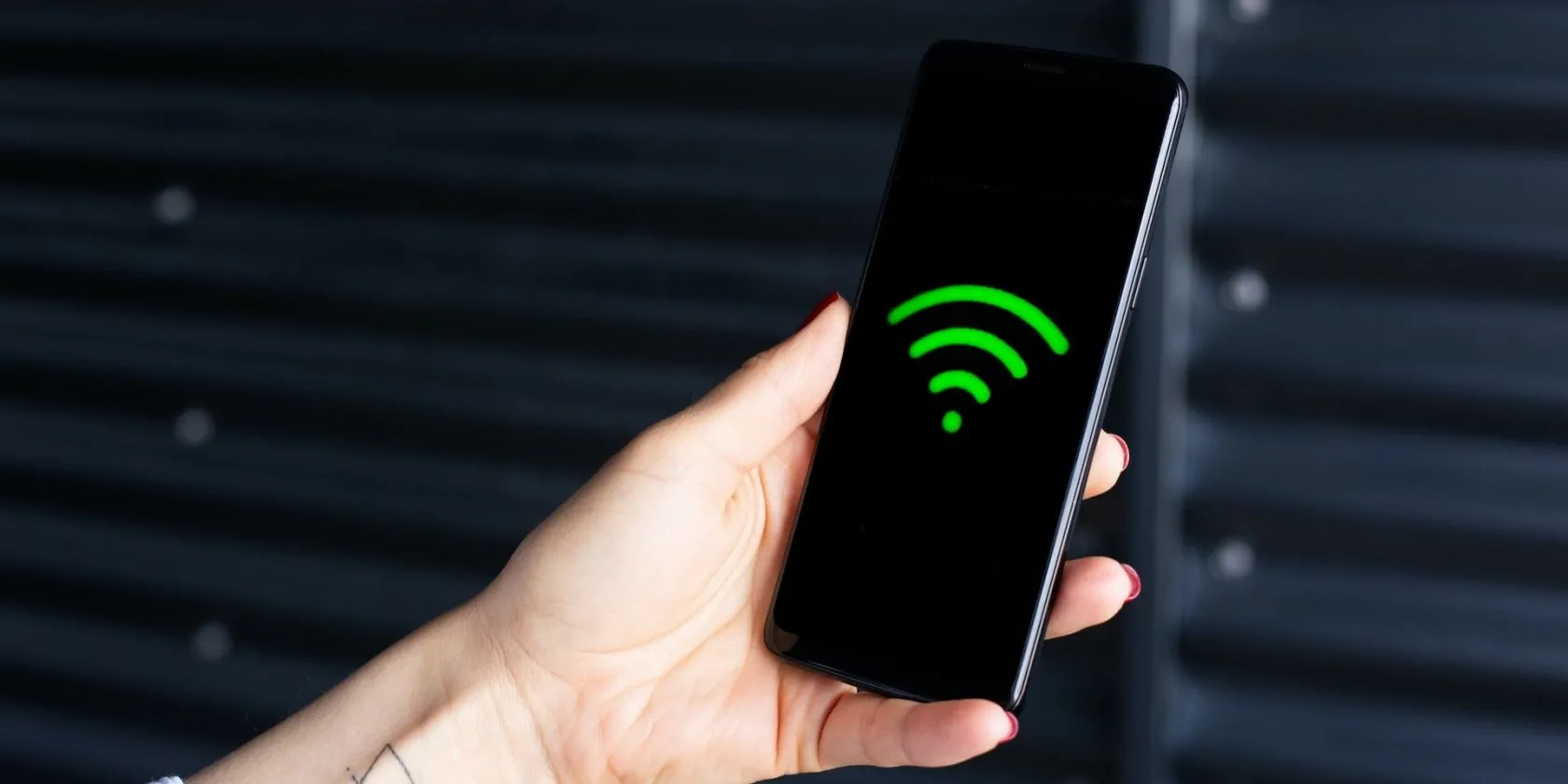 Biểu tượng Wi-Fi trên màn hình điện thoại được cầm trên tay