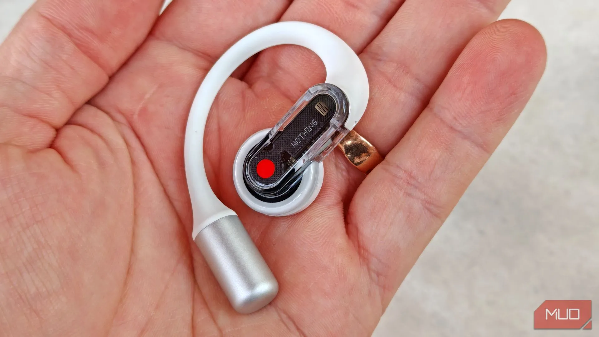 Cận cảnh một chiếc tai nghe Nothing Ear (Open) màu đen đang được cầm trên tay, cho thấy thiết kế và công nghệ của tai nghe.