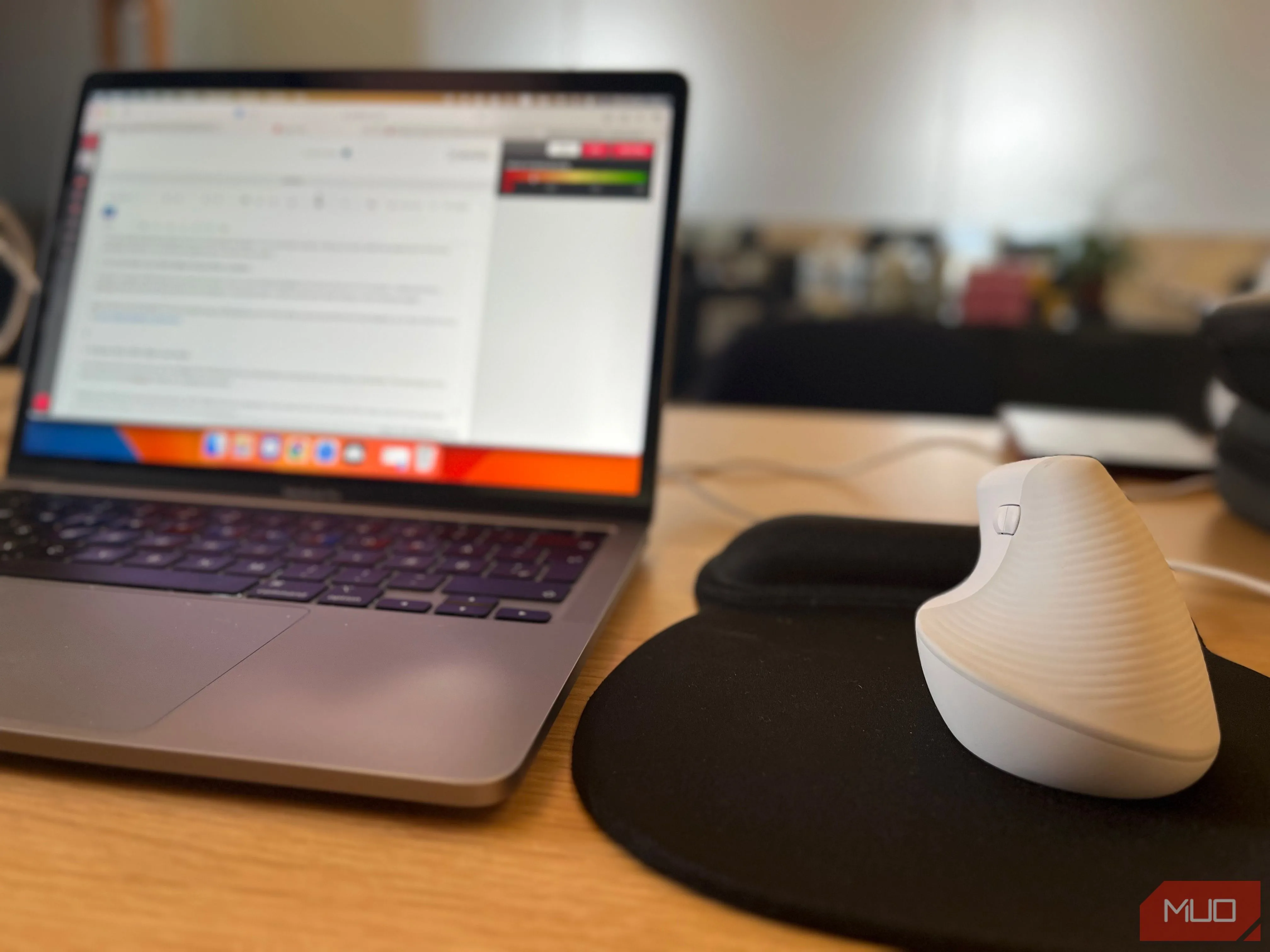 Chuột không dây và laptop trên bàn tại không gian làm việc chung, thể hiện tính linh hoạt và di động cao khi làm việc.