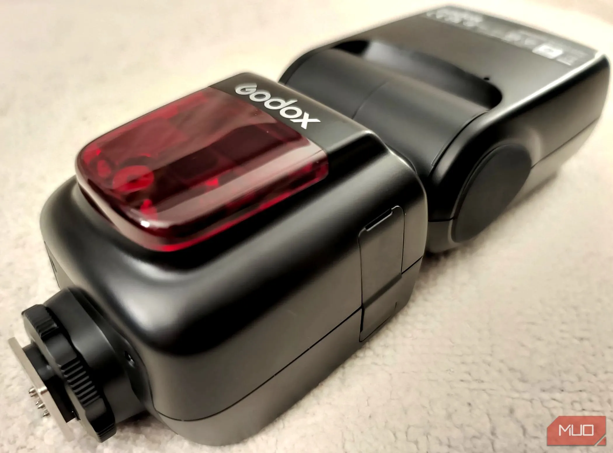 Đèn flash rời Godox V860II-C đặt trên một chiếc chăn màu be