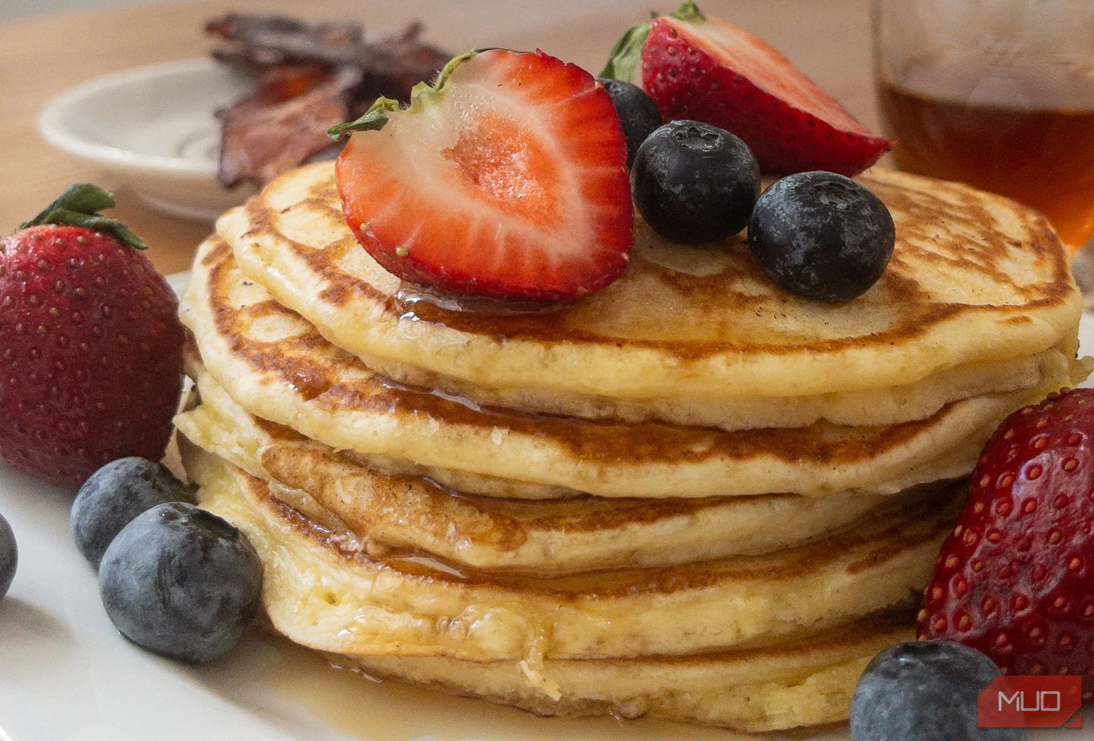 Đĩa bánh pancake xếp chồng, phủ dâu tây và kem, chụp từ góc nhìn từ trên xuống (top-down)