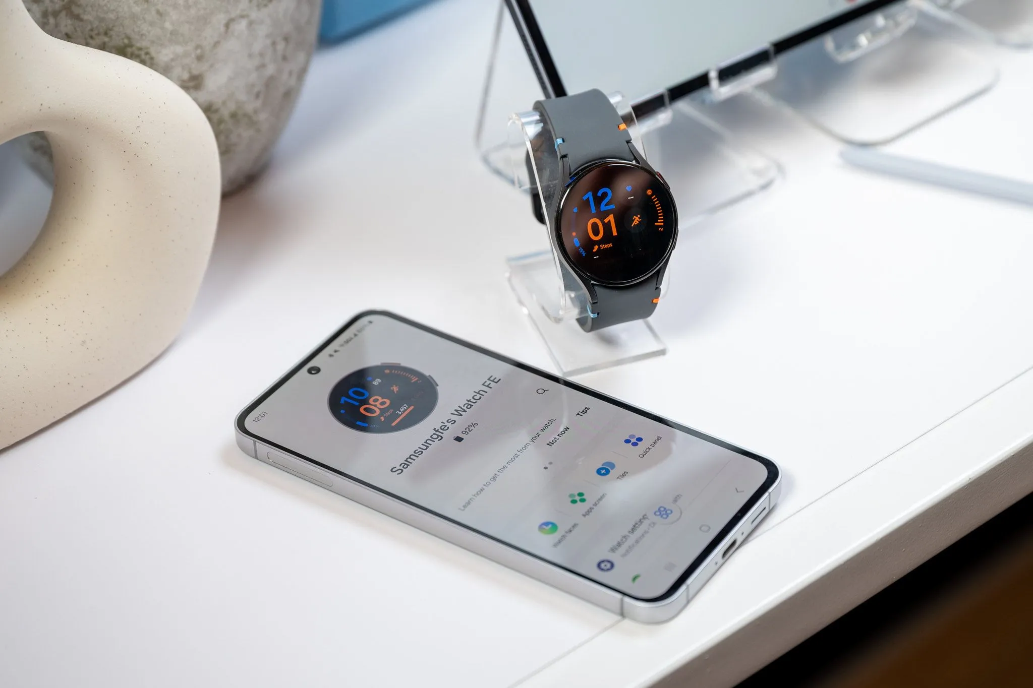 Điện thoại Samsung Galaxy S24 FE đang kết nối và sạc cho đồng hồ Galaxy Watch LTE thông qua cổng USB-C