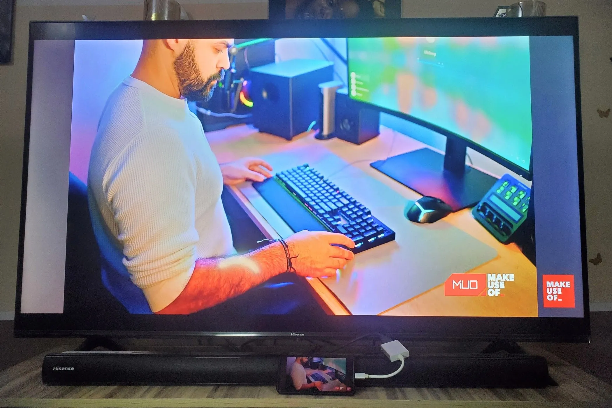 Điện thoại thông minh kết nối với TV qua adapter USB-C sang HDMI, hiển thị giao diện Samsung DeX trên màn hình lớn.