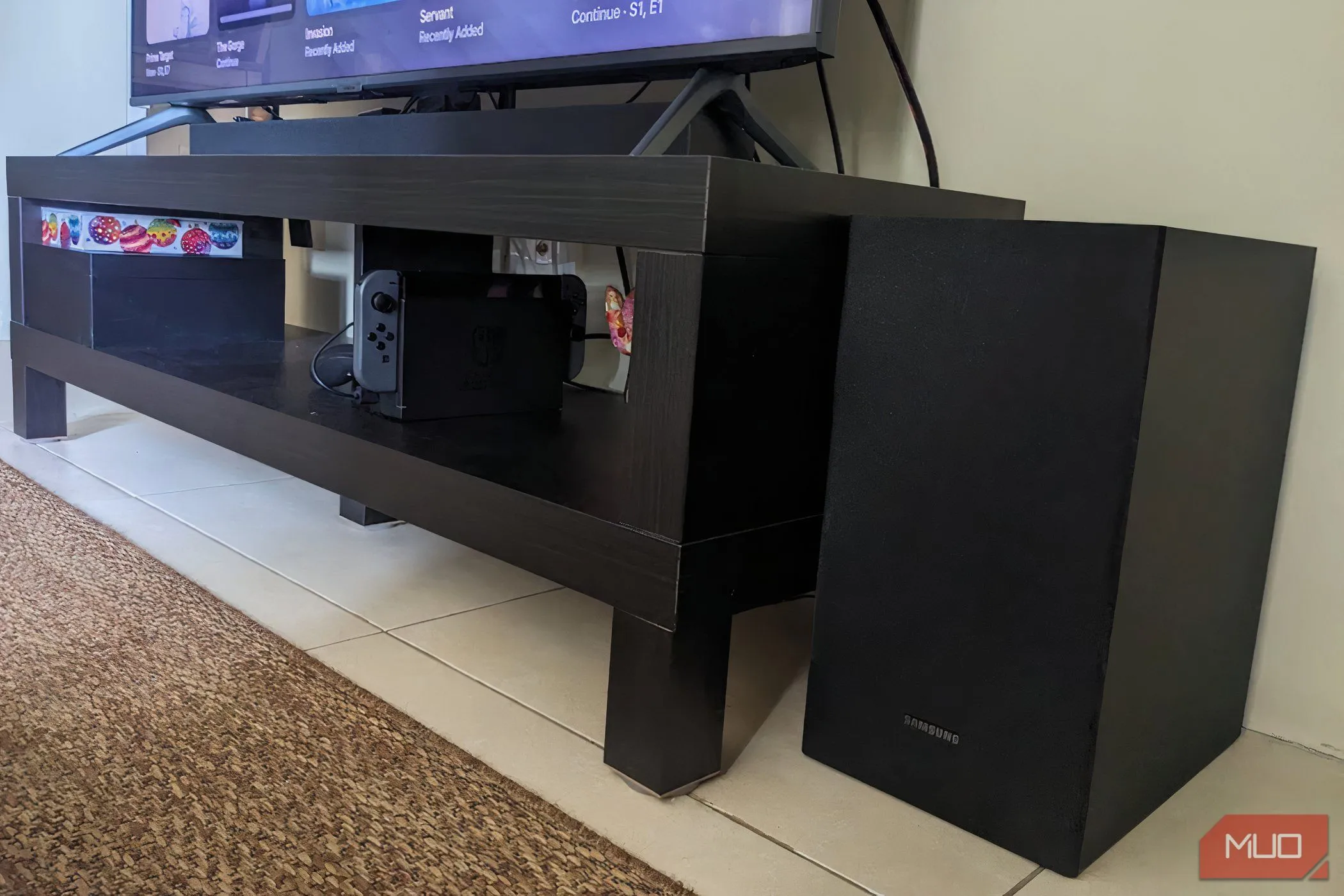 Hệ thống loa thanh soundbar và loa siêu trầm (subwoofer) đặt trong phòng khách, minh họa việc âm thanh có thể lan rộng và ảnh hưởng đến không gian xung quanh.