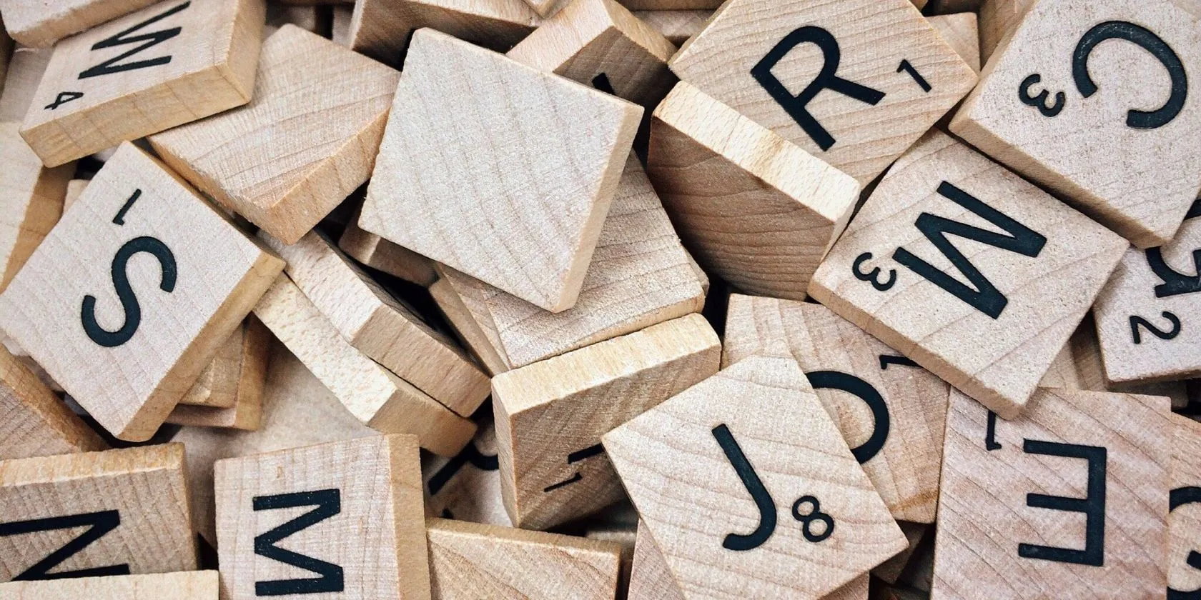 Hình ảnh các quân cờ Scrabble bằng gỗ, tượng trưng cho game giải đố từ ngữ và trò chơi trí tuệ