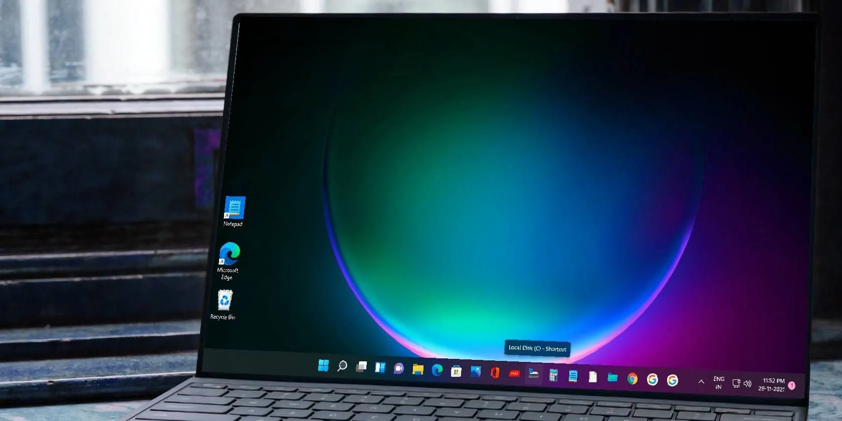 Hình ảnh máy tính xách tay chạy Windows 11 với các ứng dụng được ghim trên thanh Taskbar