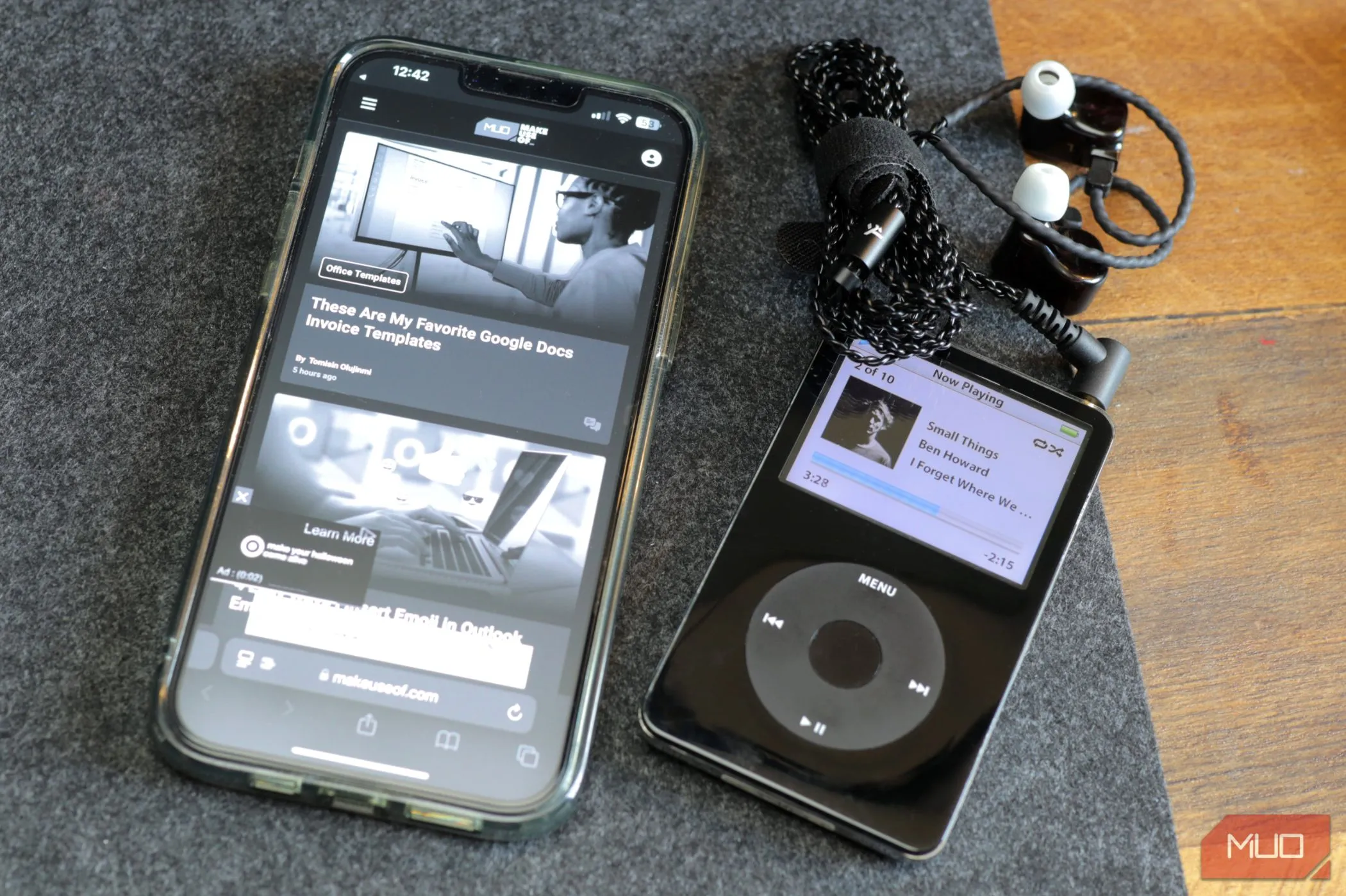 Hình ảnh một chiếc iPod màu đen và iPhone 13 màu xám trên tấm lót bàn, thể hiện sự biến hóa của iPhone thành iPod