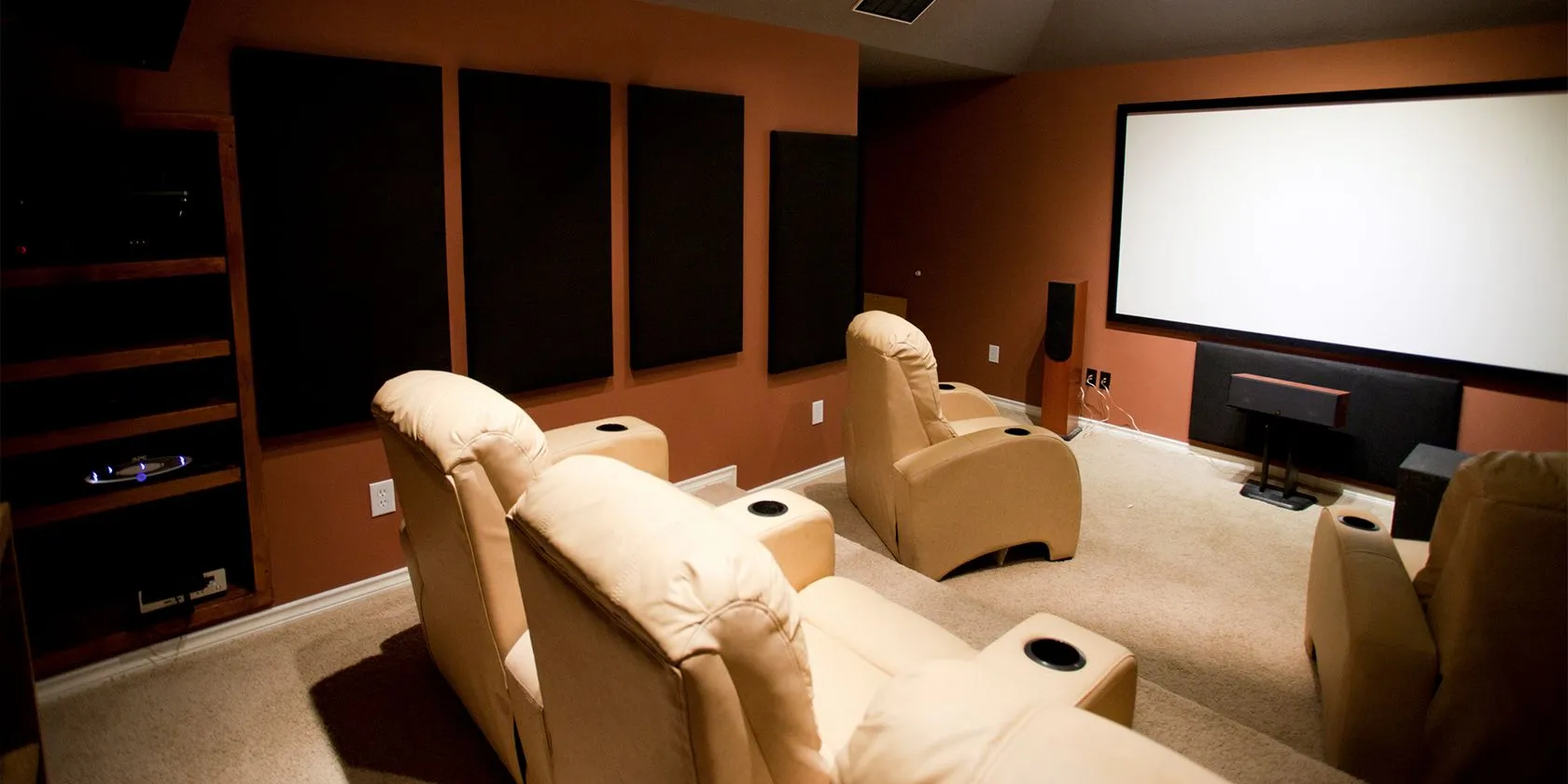 Hình ảnh một hệ thống rạp chiếu phim tại gia với màn hình lớn và ghế sofa thoải mái