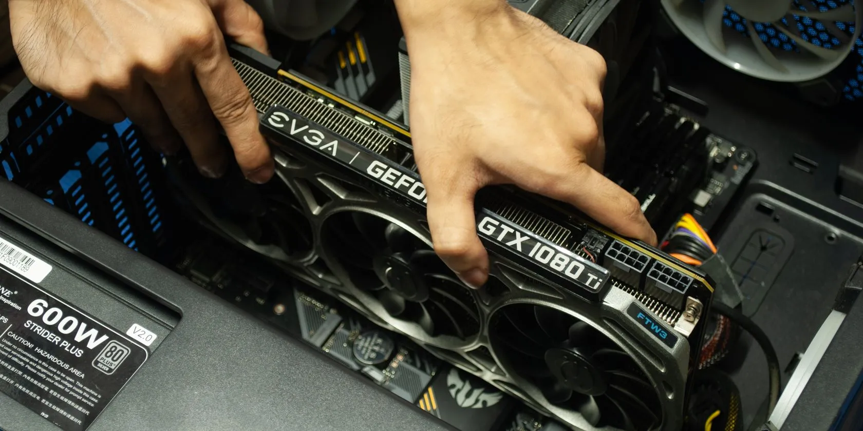 Hình ảnh một người đang cắm card đồ họa vào khe PCIe trên bo mạch chủ