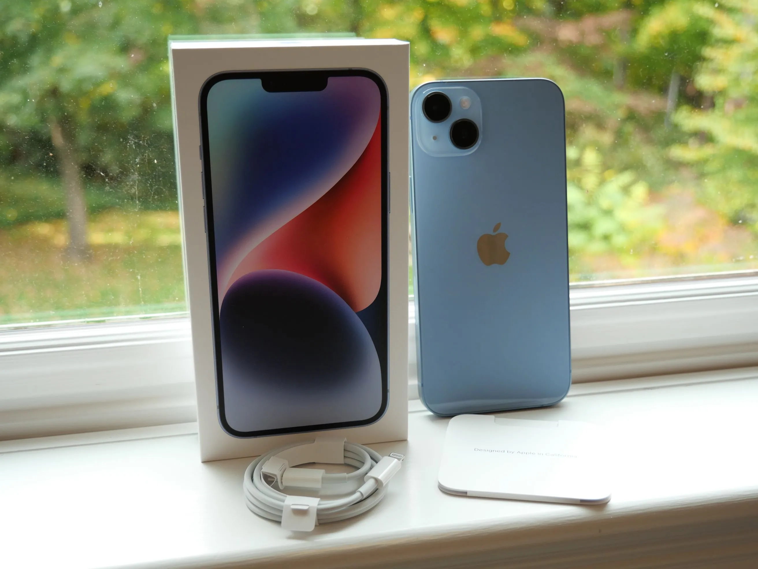 Hộp và các phụ kiện đi kèm của iPhone 14 Plus, minh họa việc Apple loại bỏ củ sạc khỏi bộ sản phẩm, chỉ còn cáp sạc.