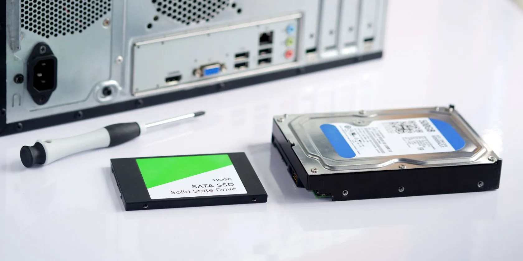 Kỹ thuật viên đang kiểm tra ổ cứng SSD và HDD trên bàn làm việc, minh họa việc theo dõi sức khỏe ổ đĩa bằng công nghệ SMART.