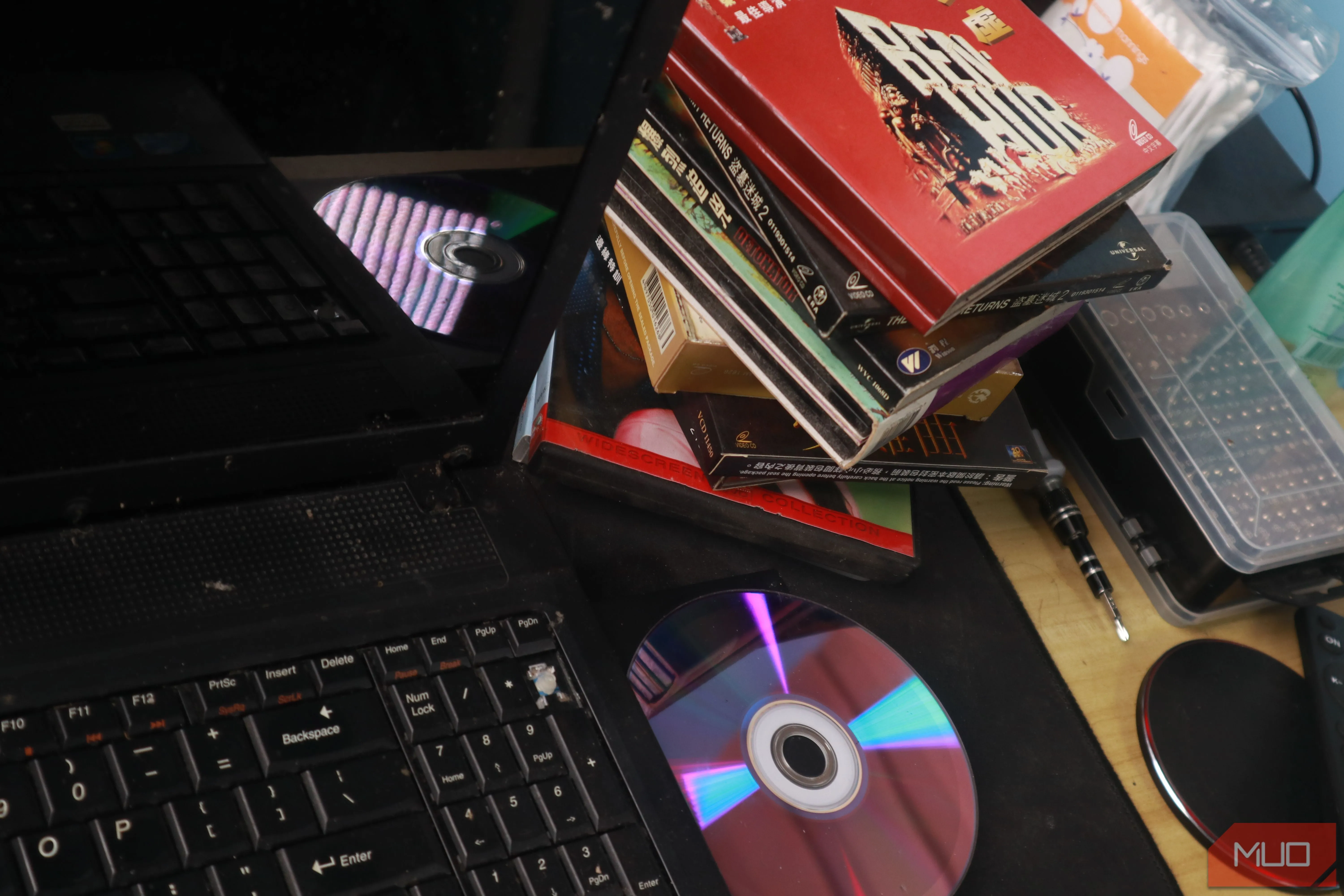 Laptop cũ có ổ đĩa quang đang trích xuất dữ liệu từ đĩa CD, minh họa cách số hóa media.