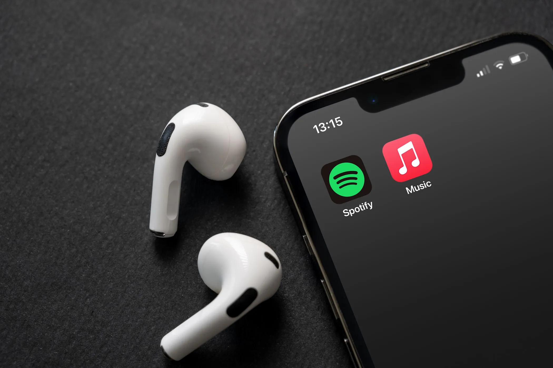Logo Apple Music và Spotify trên màn hình điện thoại di động, thể hiện sự cạnh tranh giữa hai dịch vụ nghe nhạc hàng đầu