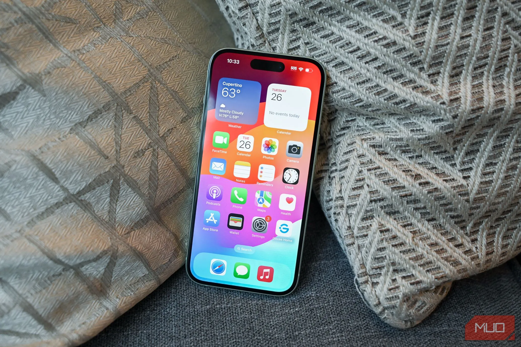 Màn hình chính của iPhone 15 đang mở, hiển thị giao diện người dùng iOS 26