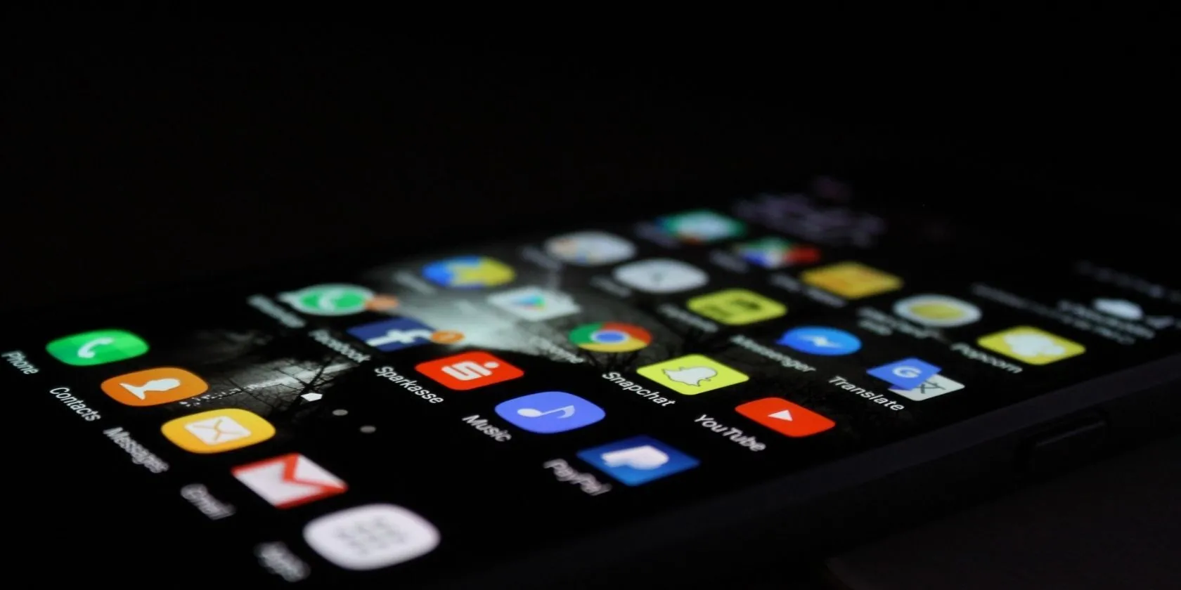 Màn hình chính iPhone với nhiều ứng dụng, cảnh báo về rủi ro khi cài đặt ứng dụng không an toàn.