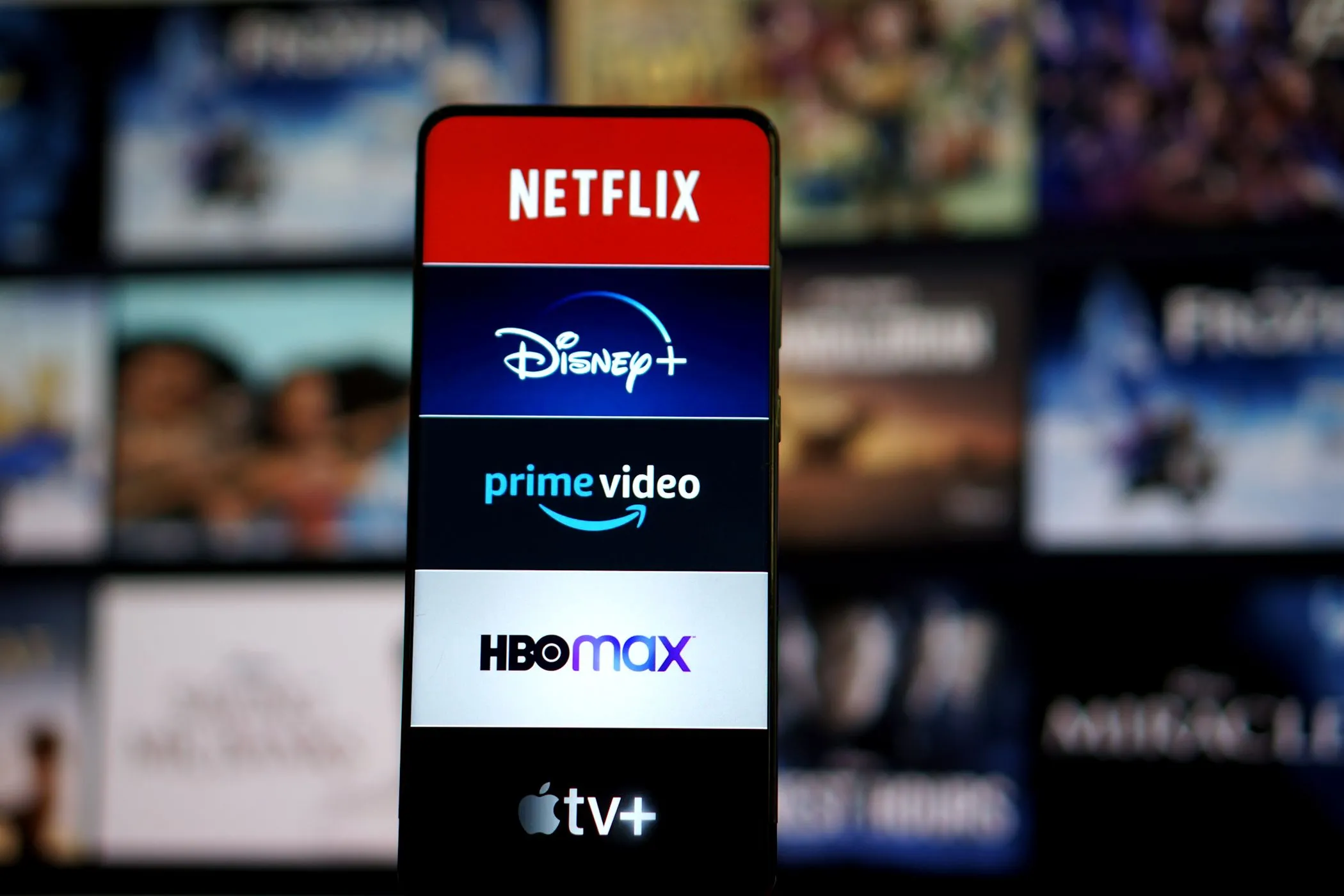 Màn hình điện thoại hiển thị logo các nền tảng streaming phổ biến như Netflix, Disney+, Spotify để minh họa việc chia sẻ tài khoản tiết kiệm chi phí