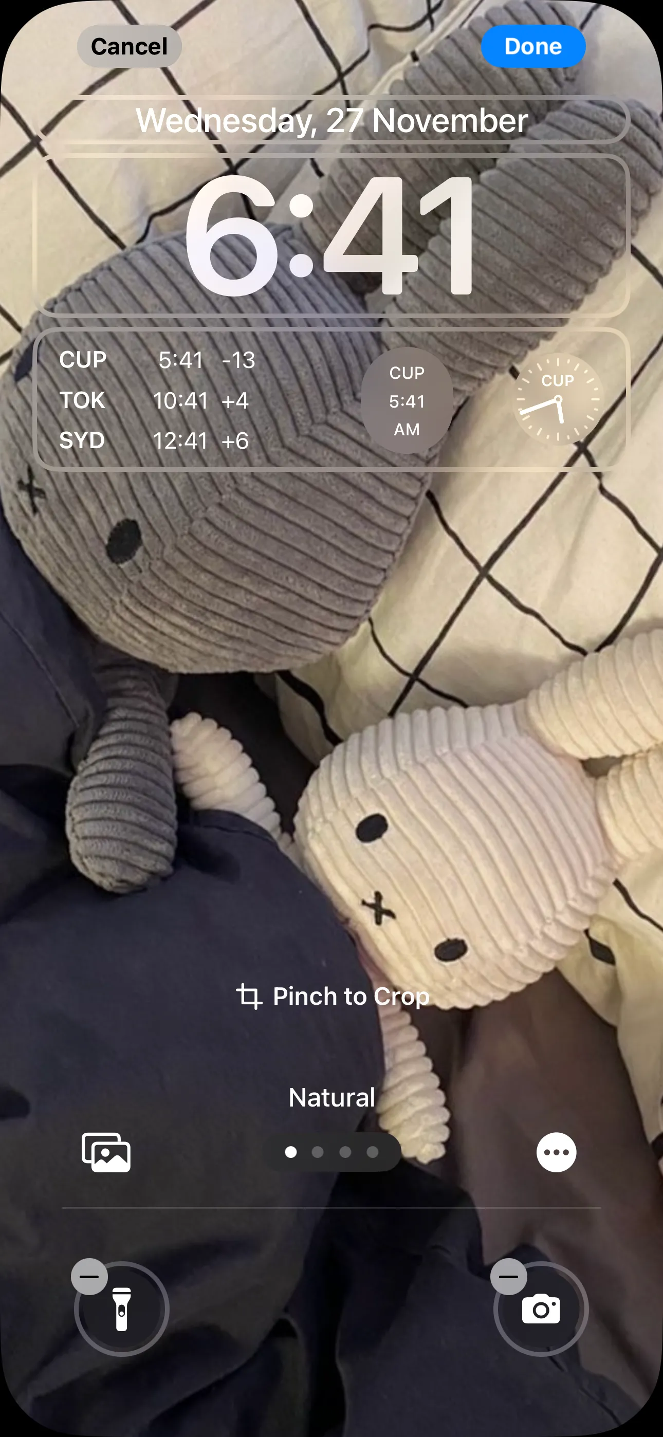 Màn hình khóa iPhone hiển thị các widget đồng hồ với nhiều múi giờ