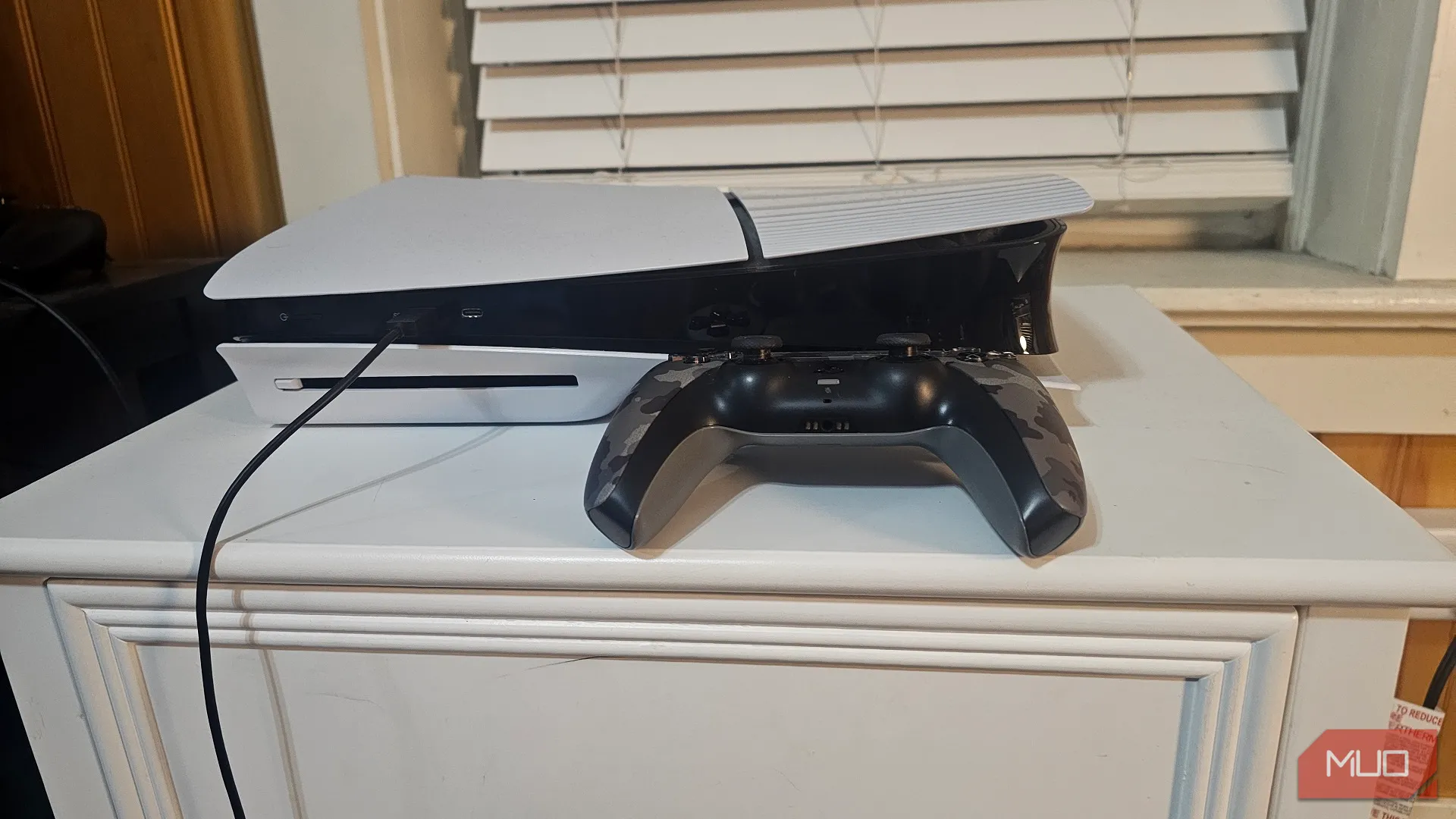 Máy chơi game PlayStation 5 và tay cầm DualSense, cho phép tải ứng dụng xem phim trực tuyến trên TV thường.