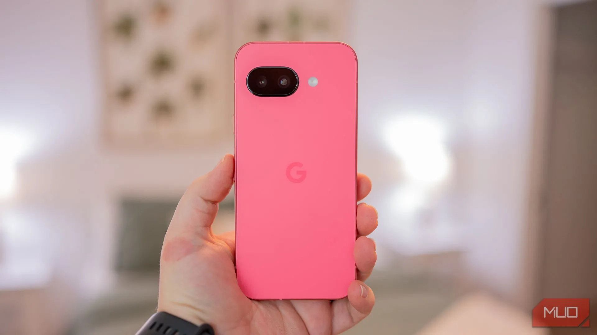 Một người đang cầm Google Pixel 9a, thể hiện mặt lưng với thiết kế tối giản, màu Iris và chất liệu cao cấp.