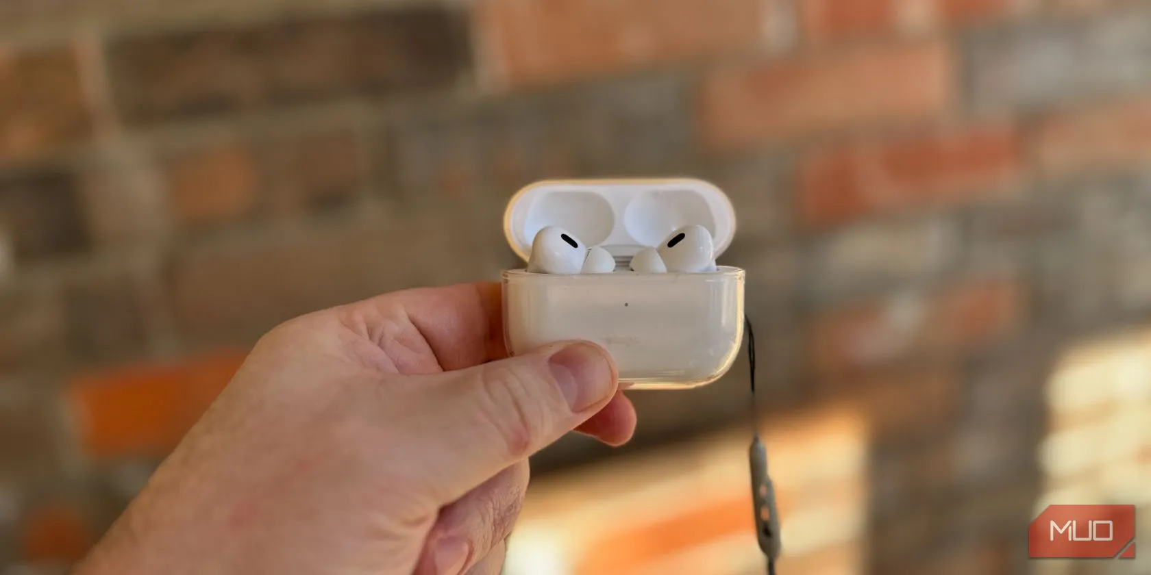 Một người đang cầm hộp sạc AirPods Pro, thể hiện tính di động và sự tiện lợi của tai nghe không dây này.