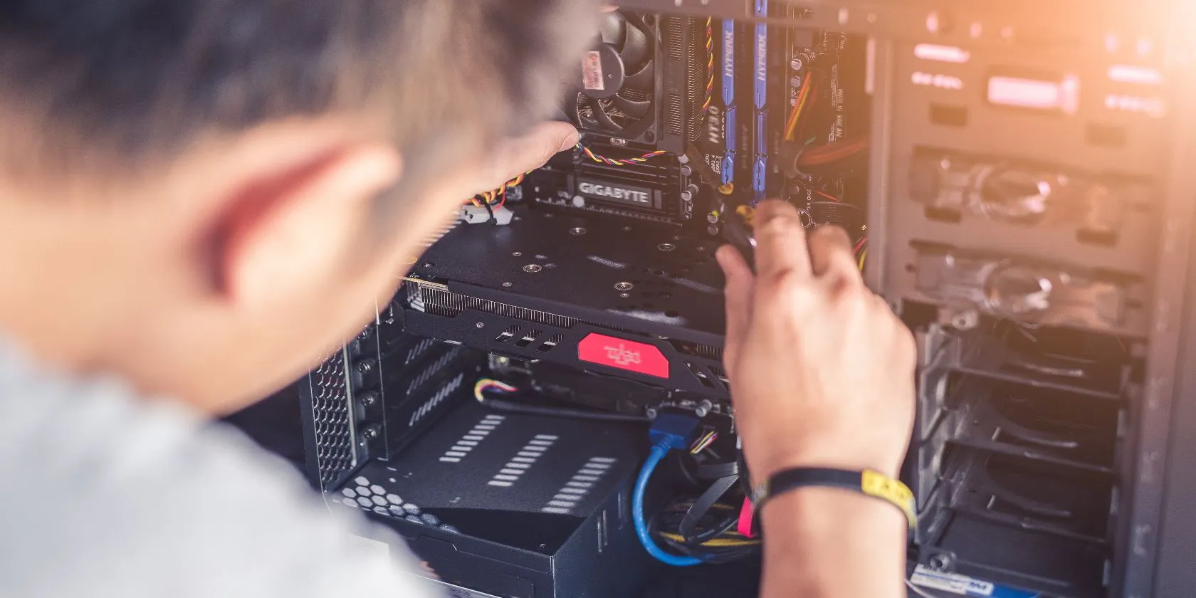 Một người đang dùng tua vít thao tác bên trong thùng máy tính để bàn, cho thấy việc sửa chữa PC dễ dàng