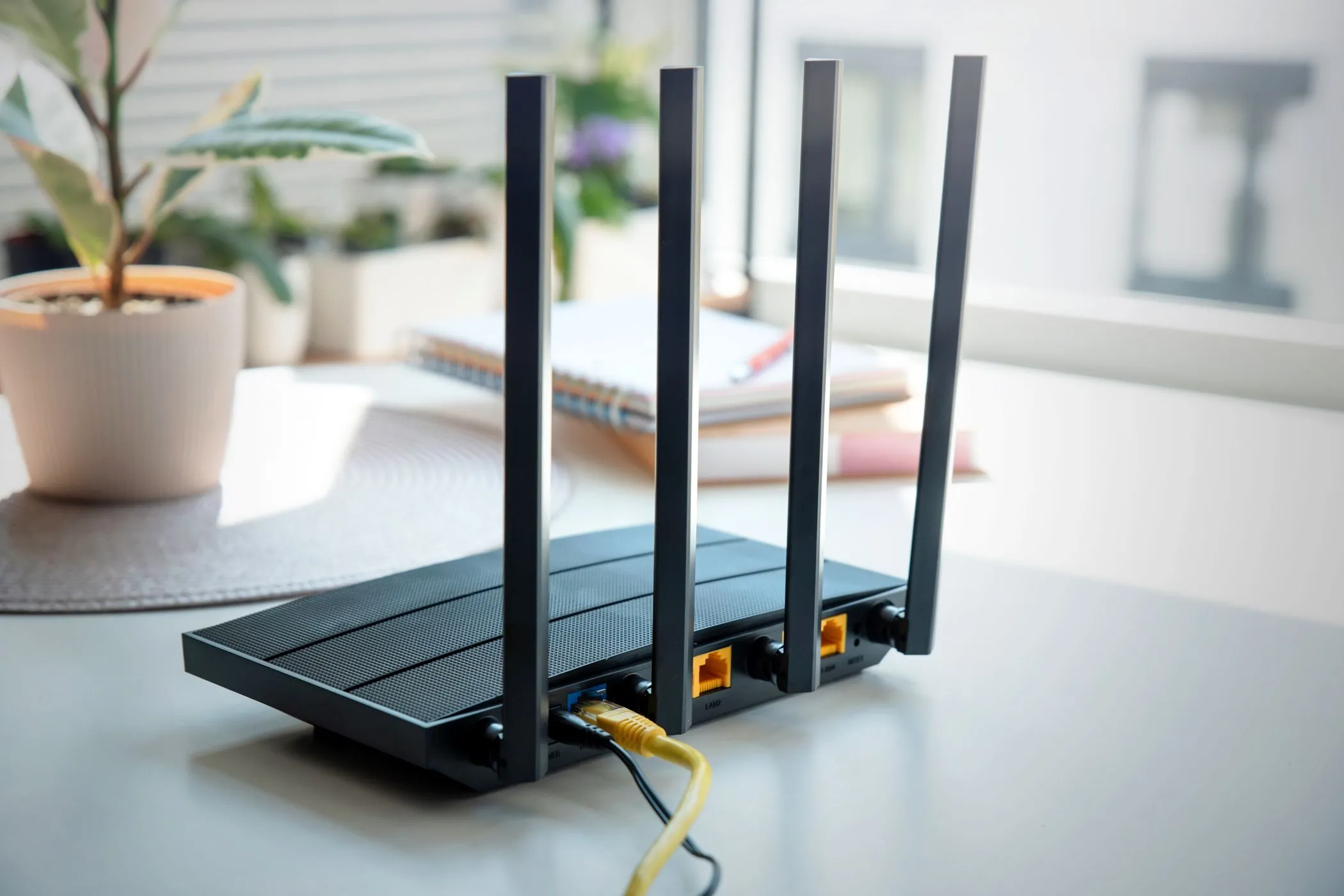 Một router Wi-Fi 4 ăng-ten màu đen đặt trên bề mặt sáng