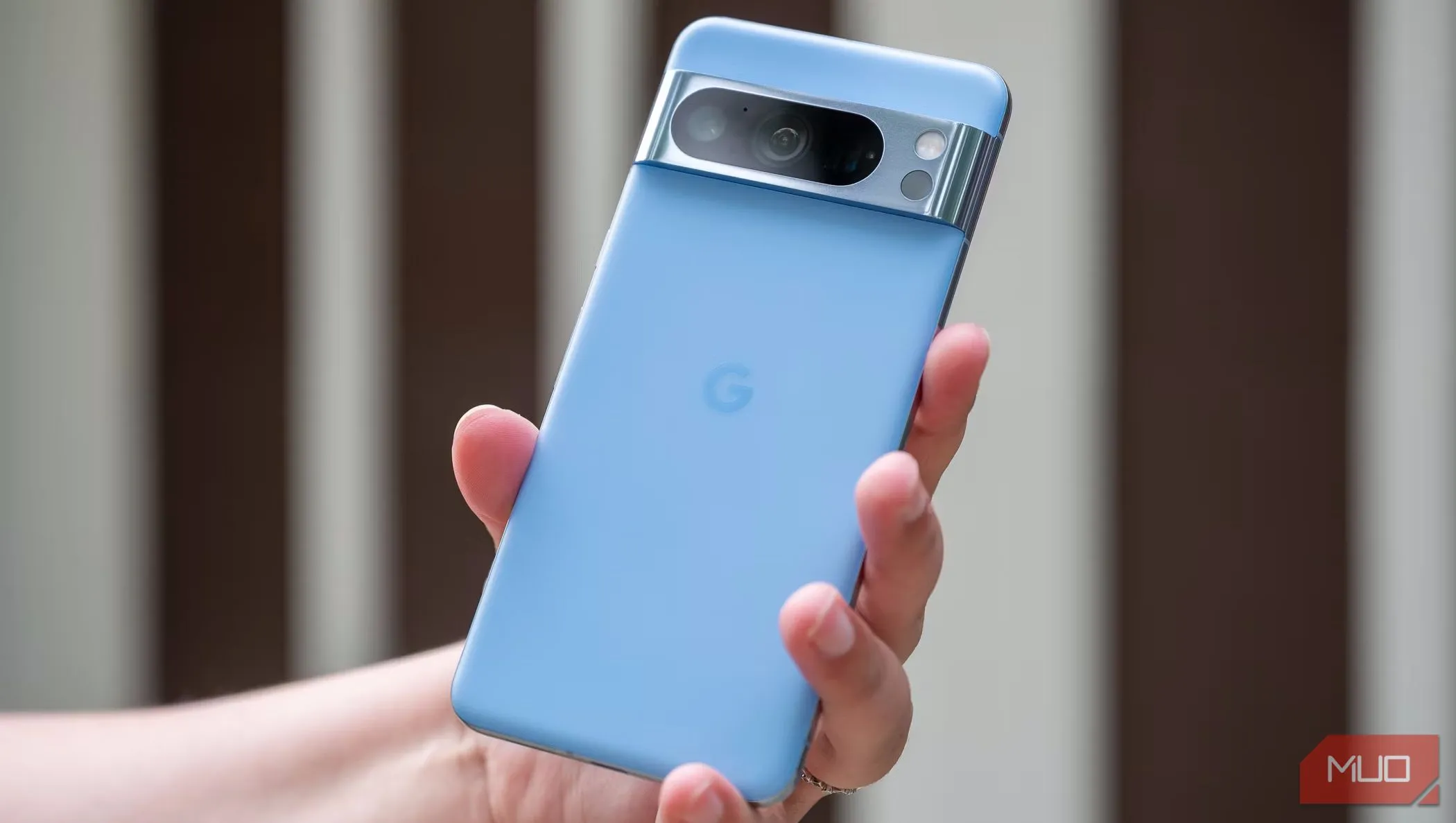 Người đàn ông cầm chiếc Pixel 8 Pro, mặt lưng của điện thoại hướng ra ngoài