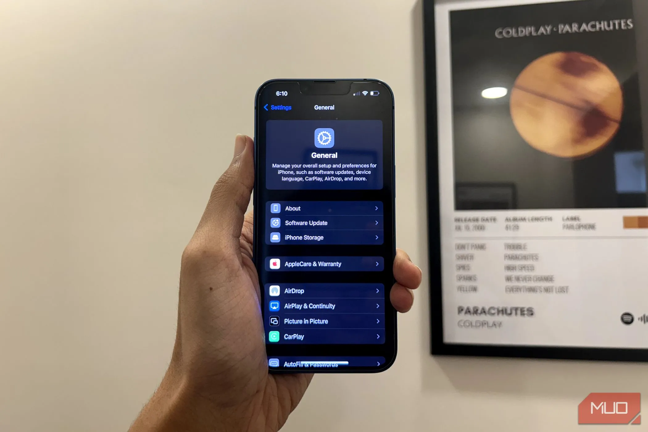 Người dùng cầm iPhone hiển thị ứng dụng Cài đặt đã được thiết kế lại trên iOS 18, vẫn giữ nguyên cấu trúc cài đặt ứng dụng.