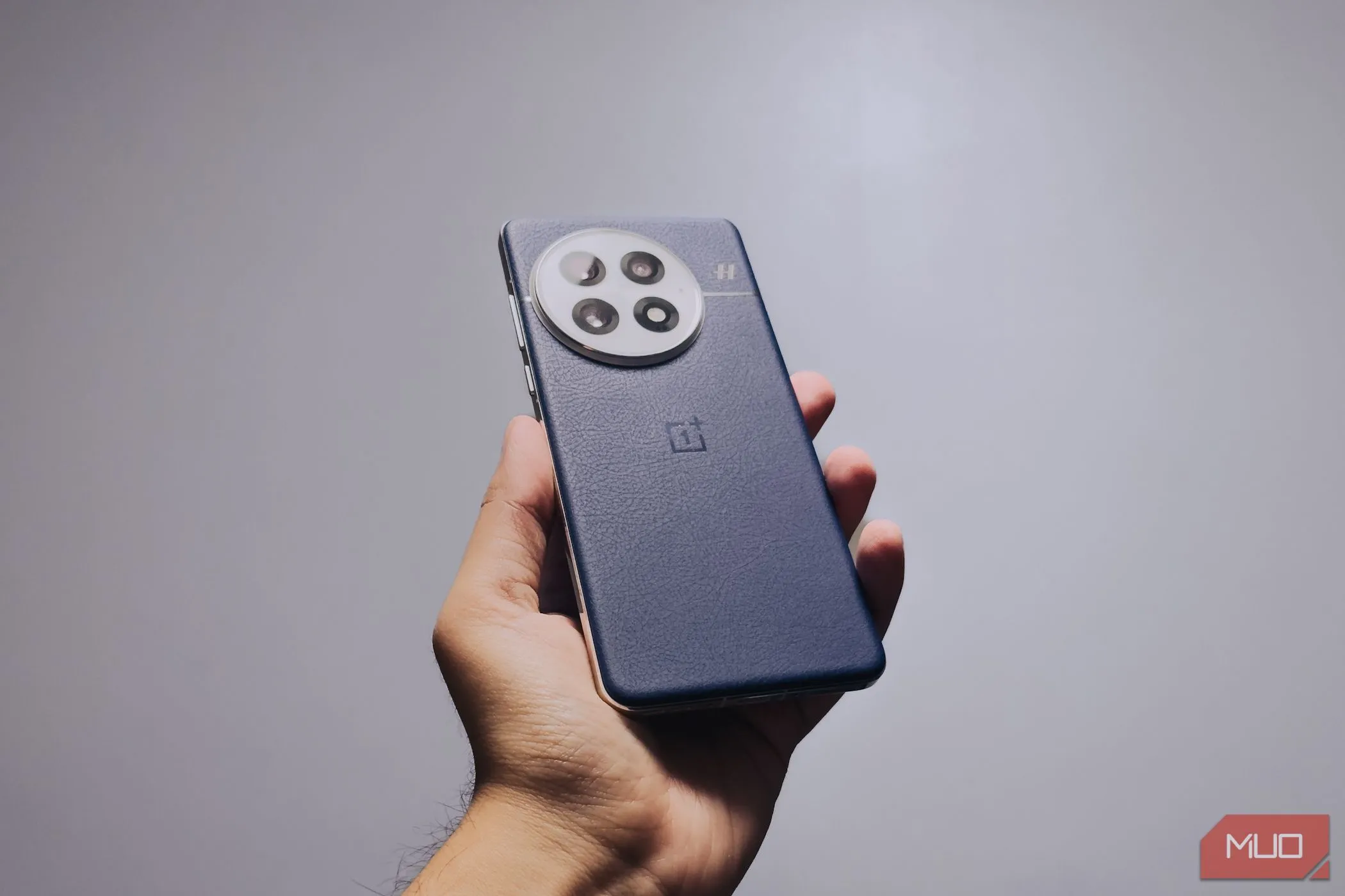 Người dùng cầm OnePlus 13 màu xanh Midnight Ocean trong tay, thể hiện cảm giác cầm nắm chắc chắn và công thái học được cải thiện