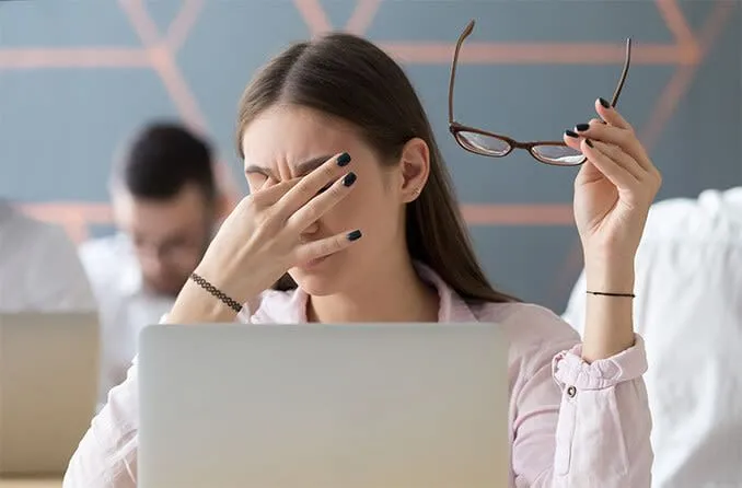 Người phụ nữ dụi mắt, thể hiện tình trạng mỏi mắt kỹ thuật số thường gặp khi nhìn màn hình quá lâu