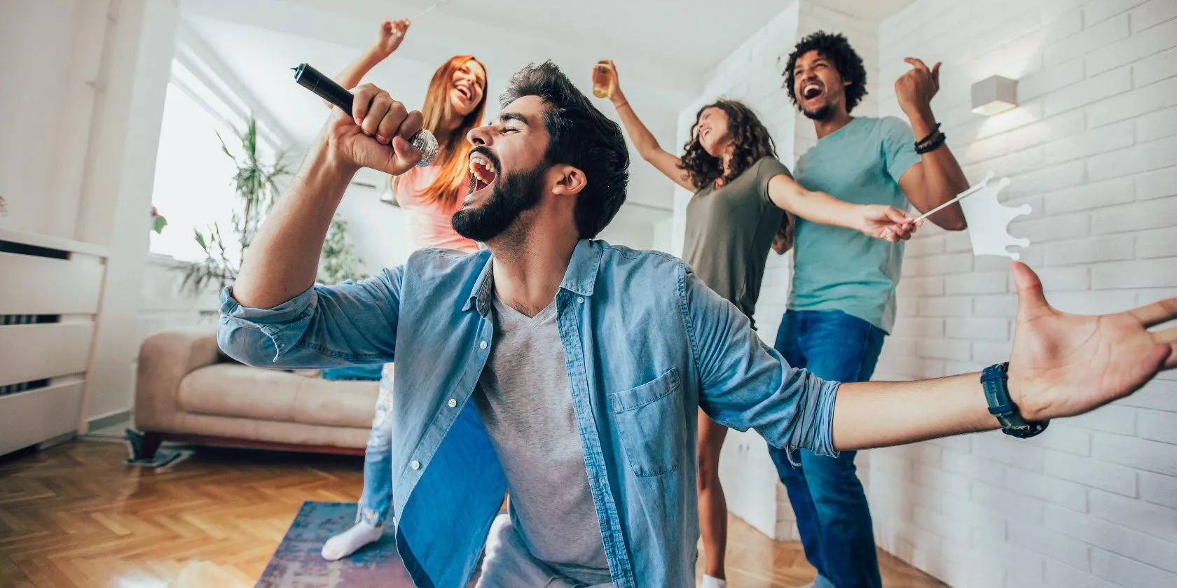 Nhóm bạn đang vui vẻ hát karaoke tại nhà với TV thông minh và dàn máy karaoke