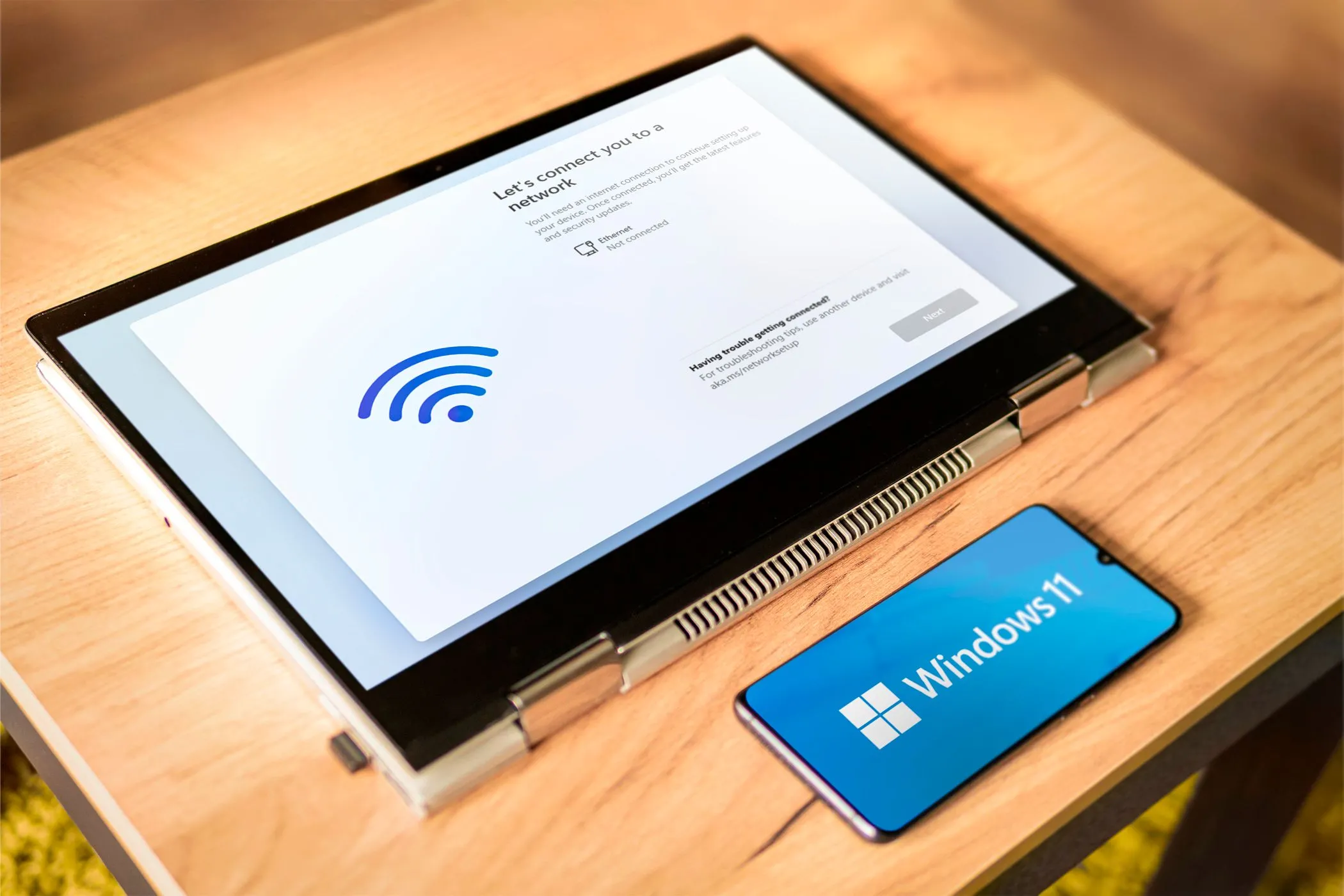 Quá trình cài đặt Windows 11 ngoại tuyến trên laptop, điện thoại hiển thị logo Windows 11