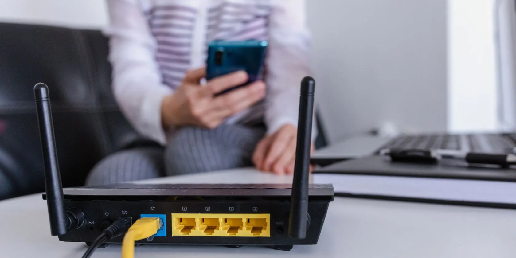Router Wi-Fi hiện đại với đèn báo hiệu và hình ảnh người dùng ở hậu cảnh