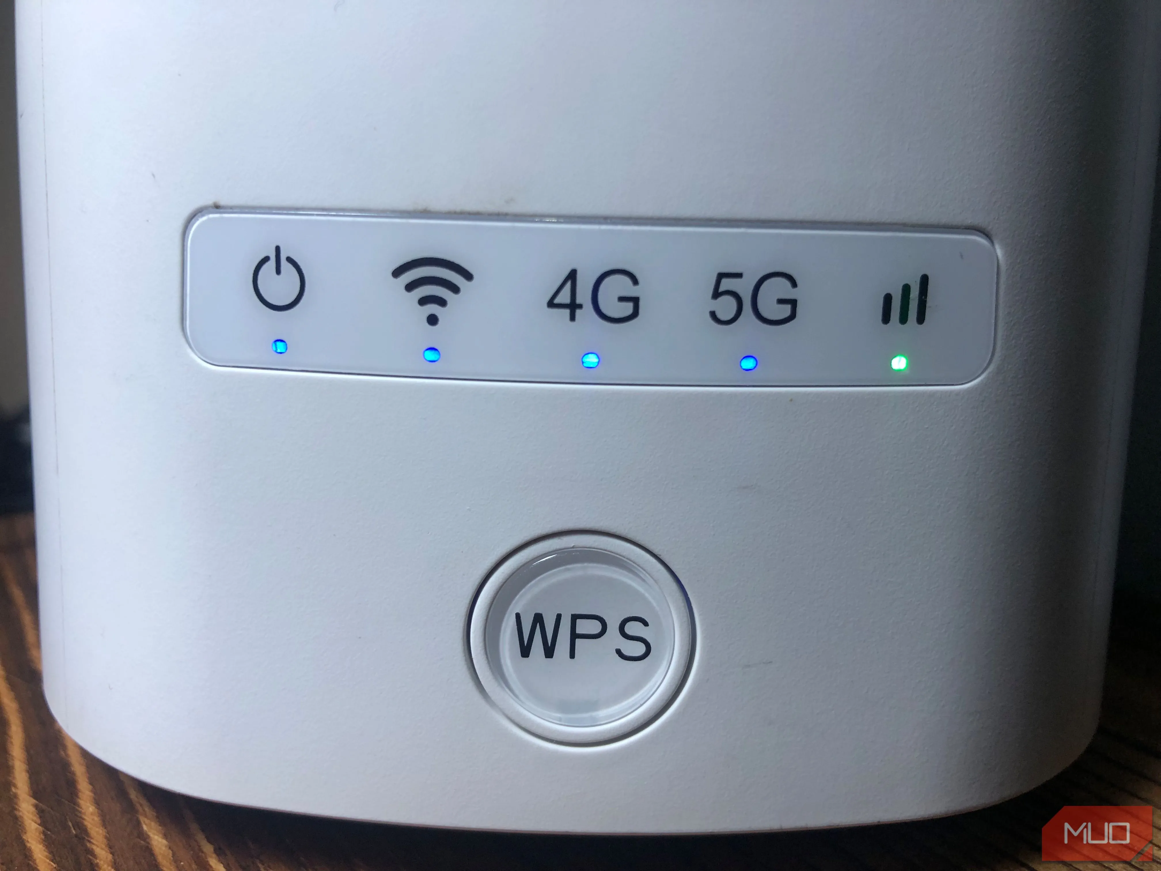 Router Wi-Fi màu trắng với nút WPS lớn ở mặt trước, thể hiện thiết bị mạng gia đình.