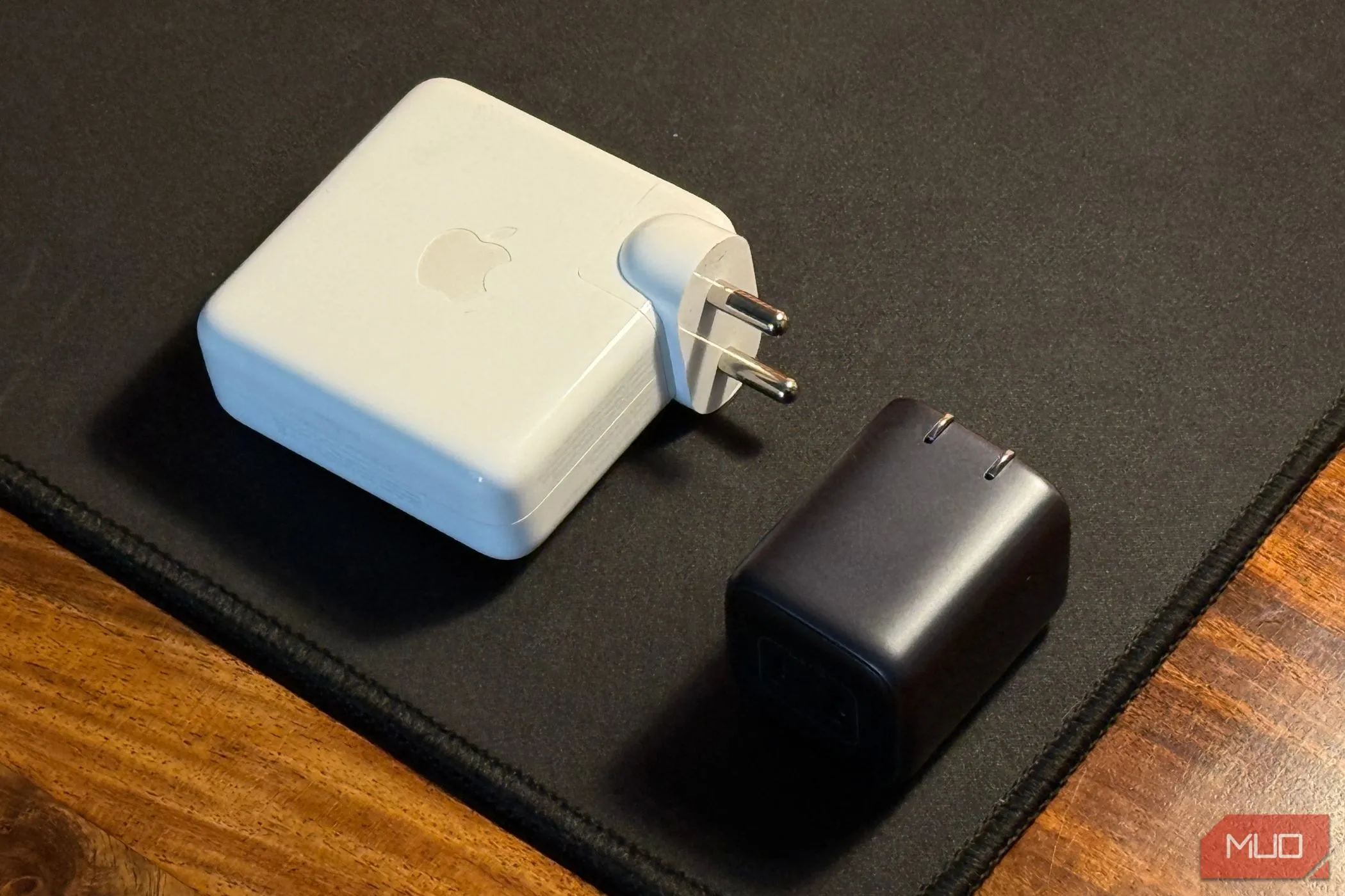 So sánh một củ sạc iPhone nhỏ gọn với củ sạc MacBook lớn hơn, minh họa sự đa dạng về kích thước và công suất của bộ sạc.