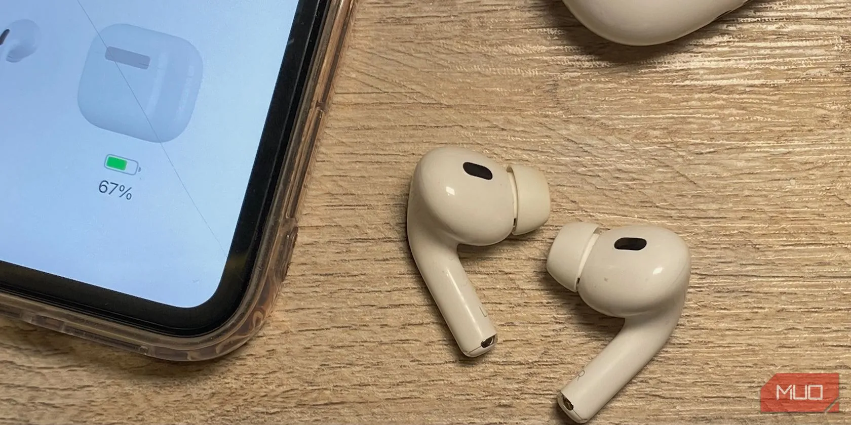 So sánh thiết kế tai nghe AirPods và iPhone trên bàn gỗ