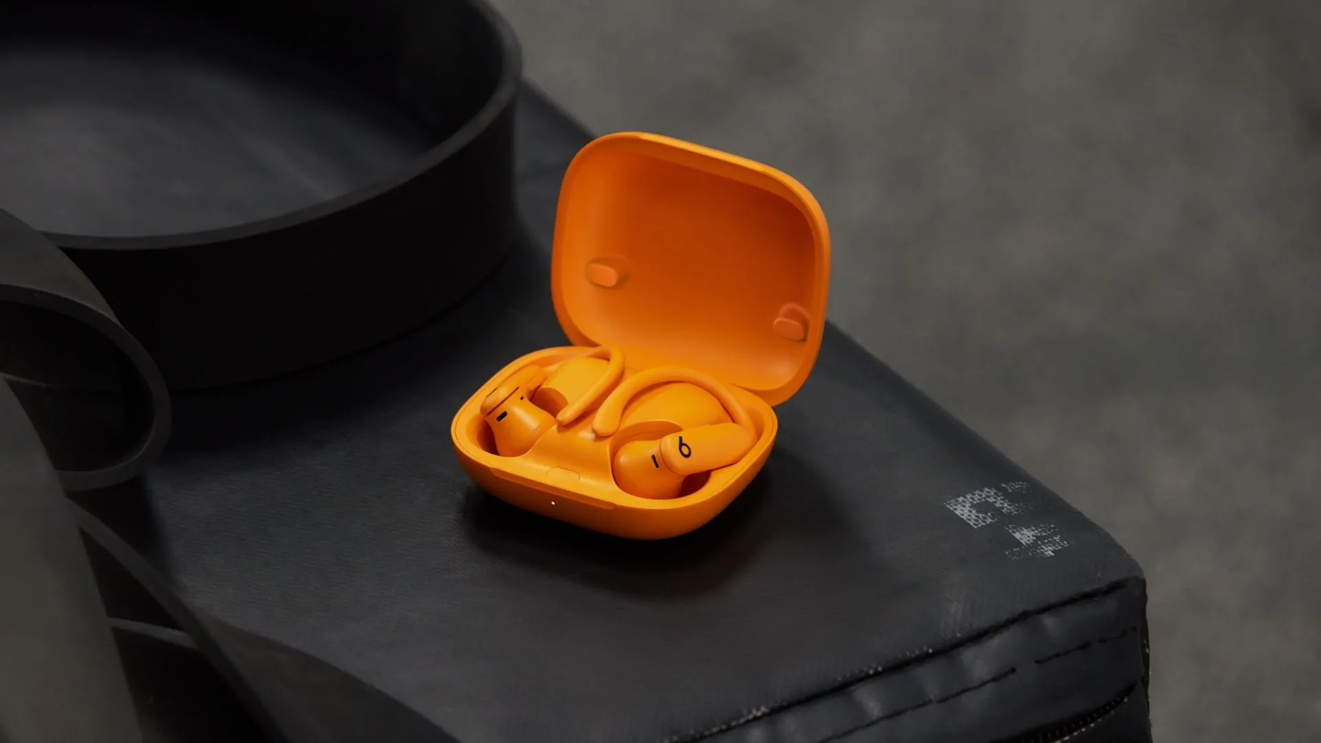 Tai nghe Powerbeats Pro 2 màu cam nổi bật, đại diện cho tính năng theo dõi nhịp tim tích hợp mới.