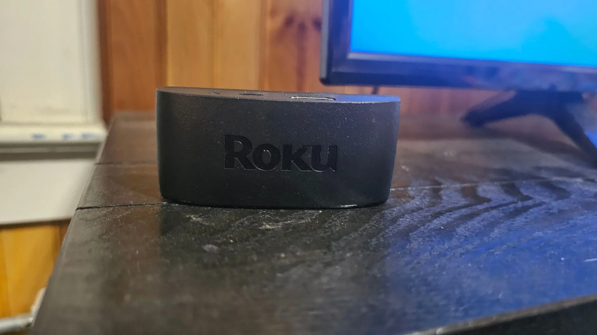 Thiết bị Roku Streaming đặt trên kệ TV, biến TV thường thành TV thông minh để xem phim trực tuyến.